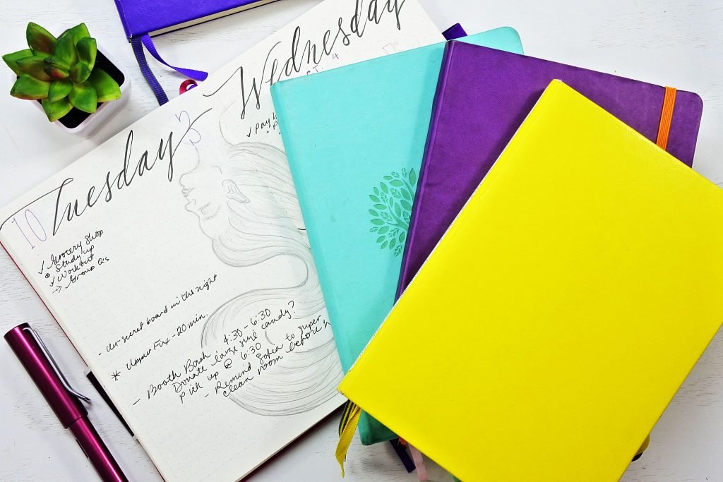 journal notebooks stacked on a table