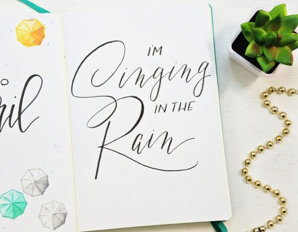 Singing in the rain hand lettered quote for a bullet journal.